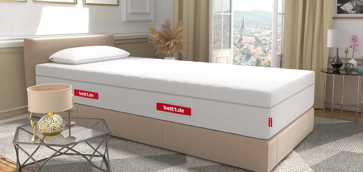 Matelas BODYGUARD® posé sur un sommier tapissier beige dans une chambre élégante avec vue sur la ville.